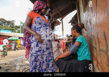 17 mai 2024, Nairobi, Kenya : un bénévole en santé communautaire (VHC) de Plan International Kenya effectue des tests de diagnostic d'hypertension gratuits sur un résident à l'occasion de la Journée mondiale de l'hypertension. La Journée mondiale de l’hypertension est célébrée chaque année pour sensibiliser au risque d’hypertension et à ses mesures préventives. Plus tôt aujourd’hui, le Programme de santé des jeunes, une initiative de sensibilisation aux maladies non transmissibles mise en œuvre par Plan International Kenya, a marqué cette journée en menant des activités porte-à-porte à Kibera par leurs volontaires de santé communautaire (VHC) et leurs médecins. (Crédit image : © Donwilson Odhiambo/SOPA Imag Banque D'Images