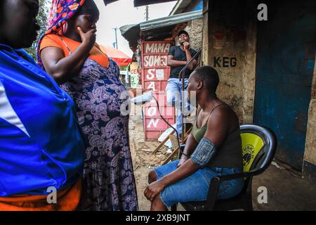 17 mai 2024, Nairobi, Kenya : un bénévole en santé communautaire (VHC) de Plan International Kenya effectue des tests de diagnostic d'hypertension gratuits sur un résident à l'occasion de la Journée mondiale de l'hypertension. La Journée mondiale de l’hypertension est célébrée chaque année pour sensibiliser au risque d’hypertension et à ses mesures préventives. Plus tôt aujourd’hui, le Programme de santé des jeunes, une initiative de sensibilisation aux maladies non transmissibles mise en œuvre par Plan International Kenya, a marqué cette journée en menant des activités porte-à-porte à Kibera par leurs volontaires de santé communautaire (VHC) et leurs médecins. (Crédit image : © Donwilson Odhiambo/SOPA Imag Banque D'Images