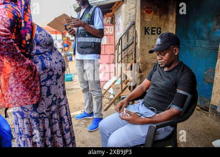 17 mai 2024, Nairobi, Kenya : un bénévole en santé communautaire (VHC) de Plan International Kenya effectue des tests de diagnostic d'hypertension gratuits sur un résident à l'occasion de la Journée mondiale de l'hypertension. La Journée mondiale de l’hypertension est célébrée chaque année pour sensibiliser au risque d’hypertension et à ses mesures préventives. Plus tôt aujourd’hui, le Programme de santé des jeunes, une initiative de sensibilisation aux maladies non transmissibles mise en œuvre par Plan International Kenya, a marqué cette journée en menant des activités porte-à-porte à Kibera par leurs volontaires de santé communautaire (VHC) et leurs médecins. (Crédit image : © Donwilson Odhiambo/SOPA Imag Banque D'Images