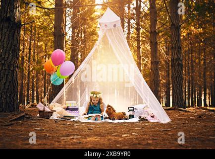 Pique-nique, fille et livre de lecture en forêt pour le développement, l'éducation ou l'histoire de conte de fées. Nature, fantaisie et jeune enfant sur couverture avec costume pour Banque D'Images