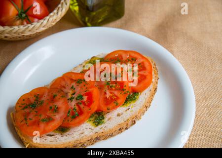 Tomate tranchée avec huile d'olive sur pain grillé. Fermer la vue. Banque D'Images