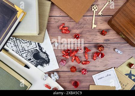 Rôle de table jouant sur fond plat avec des dés de RPG rouges, des livres de règles et des notes sur fond en bois Banque D'Images