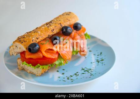 Sandwich méditerranéen : saumon fumé, tomate, laitue et les olives noires avec du pain complet. Banque D'Images