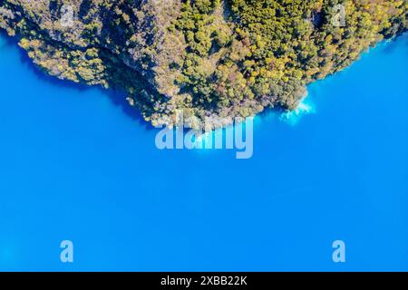 Vue aérienne du Little Blue Lake à Mount Gambier, Australie, avec une eau bleue claire entourée de terrains rocheux Banque D'Images