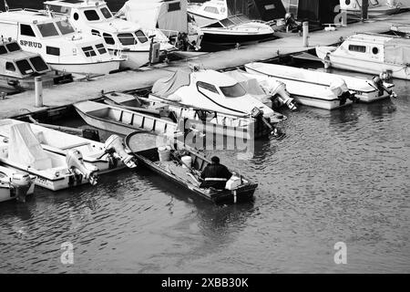 Photographie en noir et blanc d'un bateau avec un pêcheur amarrant à l'embarcadère de la « Marina internationale » à Apatin, Serbie Banque D'Images