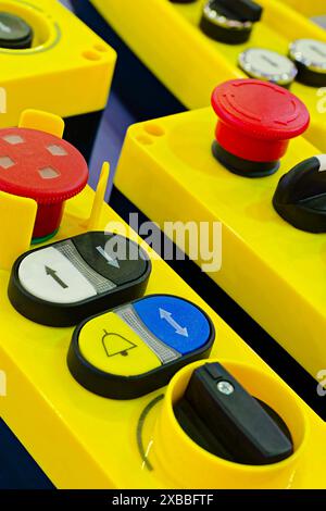 Télécommandes industrielles en plastique jaune assorties avec boutons et commutateurs, gros plan, mise au point sélective Banque D'Images