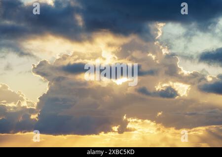 Le soleil brille à travers les nuages dans le ciel pendant le coucher du soleil, créant un beau paysage naturel avec une atmosphère calme et un vent doux à dus Banque D'Images