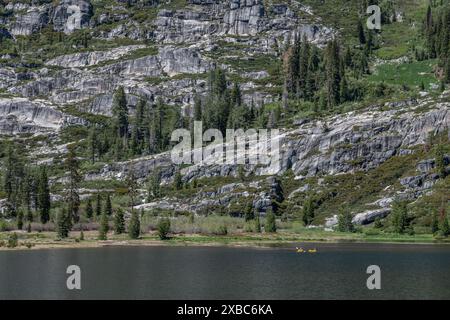 Le magnifique paysage de montagne et le lac de haute altitude dans la nature sauvage des Alpes de la Trinité de Shasta. Une paire de kayakistes éloignés pagaie à travers le lac. Banque D'Images