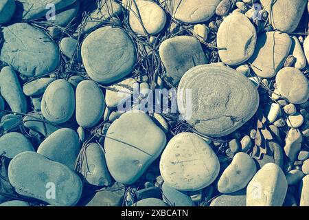 Une collection de pierres lisses et rugueuses et de cailloux dans différentes nuances de gris et beige, image de fond Banque D'Images