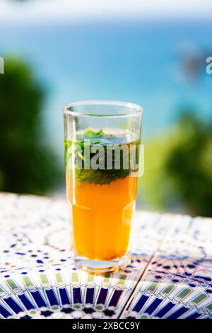 Un thé à la menthe, assis sur une table de tuiles au Café Hafa à Tanger, Maroc Banque D'Images