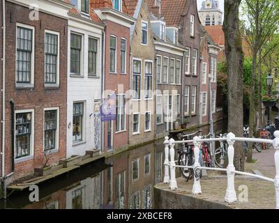 Rangée de vieilles maisons en briques et de vélos debout le long d'un canal dans une ville historique, Delft, Hollande, pays-Bas Banque D'Images