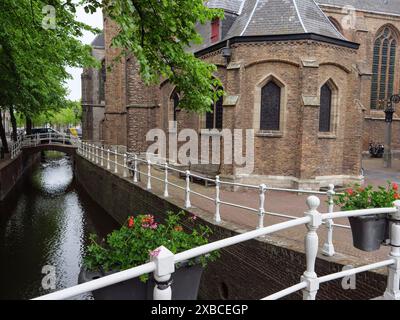 Bâtiment d'église à côté d'un canal avec des pots de fleurs et des arbres, Delft, Hollande, pays-Bas Banque D'Images