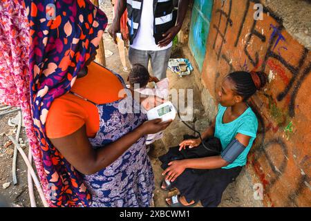 17 mai 2024, Nairobi, Kenya : un bénévole en santé communautaire (VHC) de Plan International Kenya effectue des tests de diagnostic d'hypertension gratuits sur un résident à l'occasion de la Journée mondiale de l'hypertension. La Journée mondiale de l’hypertension est célébrée chaque année pour sensibiliser au risque d’hypertension et à ses mesures préventives. Plus tôt aujourd’hui, le Programme de santé des jeunes, une initiative de sensibilisation aux maladies non transmissibles mise en œuvre par Plan International Kenya, a marqué cette journée en menant des activités porte-à-porte à Kibera par leurs volontaires de santé communautaire (VHC) et leurs médecins. (Crédit image : © Donwilson Odhiambo/SOPA Imag Banque D'Images