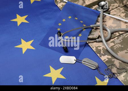 Stéthoscope, tags et uniforme militaire sur drapeau de l'Union européenne, gros plan Banque D'Images