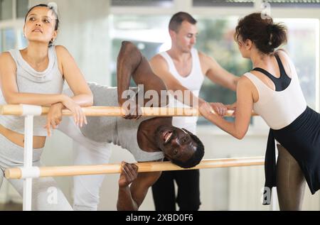 Hommes et femmes communiquent entre eux pendant la pause entre les classes de ballet dans un studio chorégraphique Banque D'Images