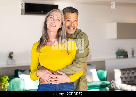 Un couple mature biracial mature embrassant et souriant chaleureusement à la maison, à la maison Banque D'Images