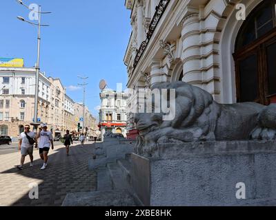 Non exclusif : KHARKIV, UKRAINE - 8 JUIN 2024 - les statues de lions flanquent les marches du bâtiment de la Banque foncière, Kharkiv, dans le nord-est de l'Ukraine. Banque D'Images