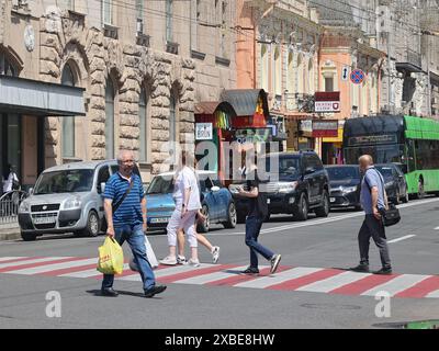 Non exclusif : KHARKIV, UKRAINE - 8 JUIN 2024 - des gens traversent une rue à un passage à zèbre, Kharkiv, dans le nord-est de l'Ukraine. Banque D'Images