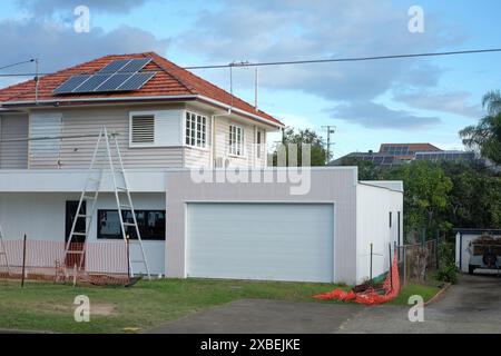 Une maison d'après-guerre sur un bloc d'angle, soulevée et subissant d'importantes rénovations de modernisation, y compris un nouveau garage, Carina, Brisbane, Australie Banque D'Images