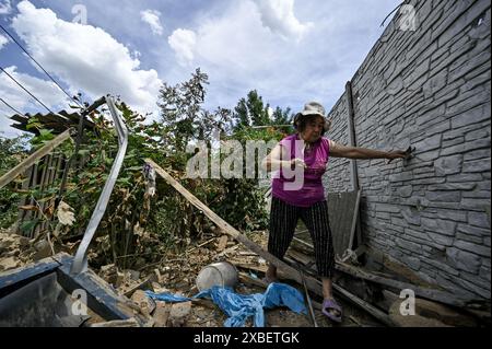 RÉGION de ZAPORIZHZHIA, UKRAINE - 10 JUIN 2024 - une femme âgée marche à travers les décombres d'une maison partiellement détruite par une attaque de drone russe, Orikhiv, région de Zaporizhzhia, sud-est de l'Ukraine. Banque D'Images