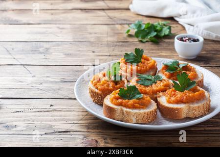 Sandwichs avec pain courgettes caviar tomates oignons. Plats végétariens faits maison. Espace de copie de fond en bois de légumes cuits en conserve Banque D'Images