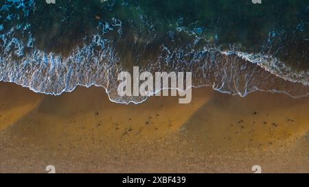 Vue aérienne : plage isolée, vagues tranquilles. Banque D'Images