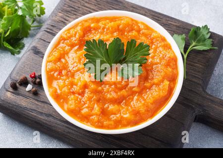 Caviar fait maison à partir de tomates courgettes et d'oignons dans une plaque de céramique, sur un fond gris. Conserves de production maison, conserves de légumes cuits en conserves Banque D'Images