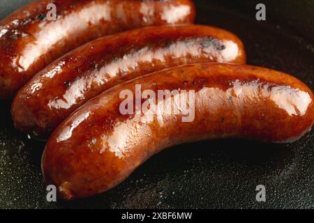 poêle de saucisse de bœuf fumé rouge juteux séché sur une poêle en fonte Banque D'Images