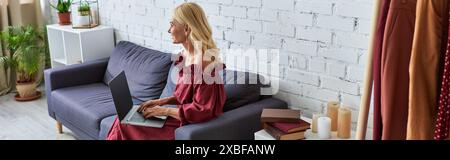 Femme sophistiquée dans une tenue élégante, en utilisant son ordinateur portable. Banque D'Images