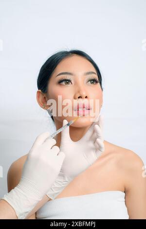 Femme asiatique sophistiquée avec updo obtenant l'injection de remplissage Banque D'Images