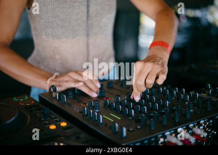 Femme DJ mains créer et réguler la musique sur console dj mixeur dans un festival de musique Banque D'Images