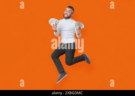 Homme sautant dans l'air avec de l'argent Banque D'Images