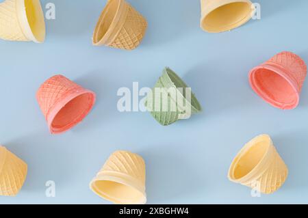 Composition de motif faite de cônes de crème glacée colorés sur fond bleu pastel. Concept créatif estival. Disposition minimale de crème glacée. Banque D'Images