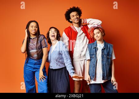 Un groupe diversifié de jeunes amis, y compris une personne non binaire, debout ensemble dans une tenue élégante dans un cadre de studio. Banque D'Images