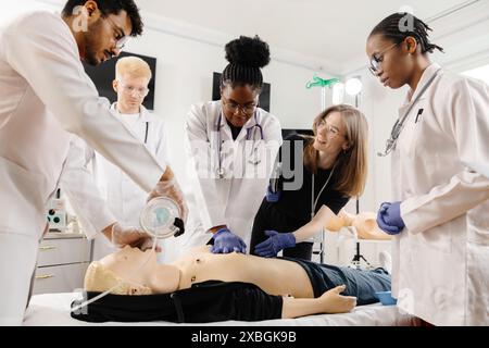 Les étudiants en médecine apprennent les techniques de RCP et de premiers soins au cours d'une séance de formation à l'aide d'un mannequin de RCP. Banque D'Images