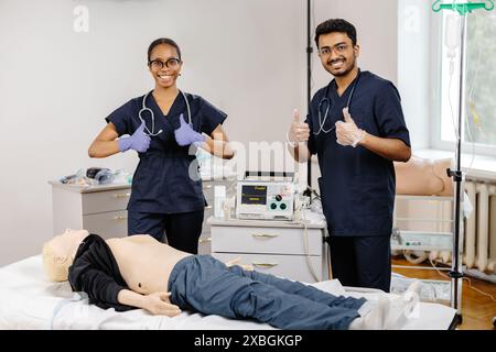 Deux étudiants en médecine pratiquent la RCR sur un mannequin dans une chambre d’hôpital. Banque D'Images