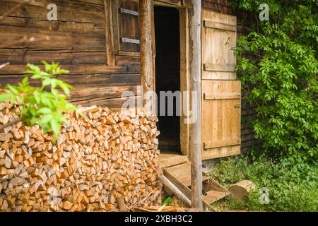 Pile de bois de chauffage devant une grange en bois dans les Alpes Banque D'Images