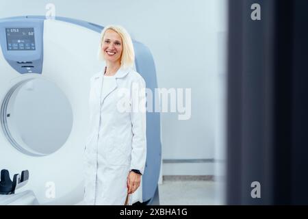 Une femme en blouse blanche se tient devant un appareil d'imagerie médicale Banque D'Images