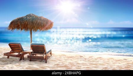 Chaises sous Parasol à Sand Beach avec lumières Bokeh abstraites défocalisées sur l'océan Banque D'Images