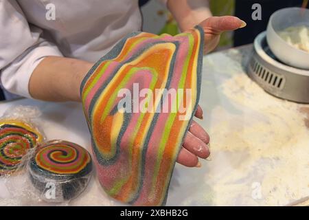 Pâte colorée pour faire des pâtes dans les mains d'un chef. Nourriture Banque D'Images