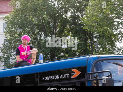 Manifestant vêtu de rose sur le toit d’un bus affrété par la police lors de la manifestation « avertissement de tempête » organisée par extinction Rebellion Finland à Kaisaniemi. Banque D'Images