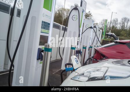 Les véhicules électriques se chargent à la station-service de l'autoroute Annandale sur l'A74 (M) près de Lockerbie Écosse Banque D'Images