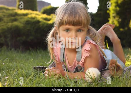 Petite fille avec des poussins mignons sur l'herbe verte à l'extérieur Banque D'Images