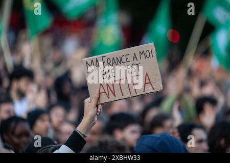 Un manifestant tient une pancarte qui dit « ma France est Antifa » au milieu de la foule pendant la manifestation. À la suite de la victoire de Jordan Bardella, du rassemblement national, aux élections européennes du 9 juin et de la décision controversée du président français Emmanuel Macron de dissoudre l'Assemblée nationale, des milliers de personnes se sont rassemblées pour la troisième journée consécutive à la place République dans une manifestation massive contre l’extrême droite et en faveur de la coalition du Front populaire, créée par les partis de gauche la France insoumise, les socialistes, les communistes et les écologistes. Banque D'Images