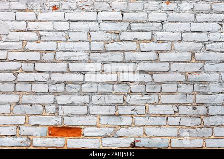 Texture de mur de briques grunge peinte en blanc avec une peinture manquante Banque D'Images