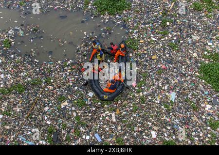 West Bandung Regency, Indonésie. 12 juin 2024. Photo aérienne des officiers nettoyant des tas de déchets dans la rivière Citarum Batujajar, West Bandung Regency, West Java, Indonésie, le 12 juin, 2024. la pile d'ordures dans le Citarum, dans le district de Batujajar, est estimée à 3 kilomètres de long et 60 mètres de large, et le volume de déchets plastiques, estimé à plus de 100 tonnes. (Photo de Rasyad Yahdiyan/INA photo Agency/Sipa USA) crédit : Sipa USA/Alamy Live News Banque D'Images