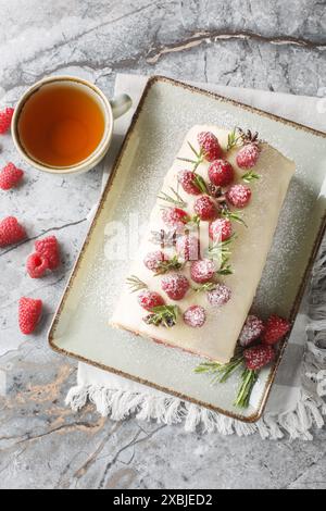 Gâteau aux framboises de Noël rouler un gâteau éponge léger et moelleux à la vanille roulé avec une garniture de fromage à la crème, confiture de framboises et gros plan de baies sur le pla Banque D'Images