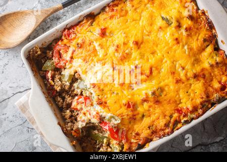 Casserole couches de bœuf haché, fromage, légumes frais et poivrons jalapeno cuits en gros plan sur le plat de cuisson sur la table. Vue de dessus horizontale de Banque D'Images