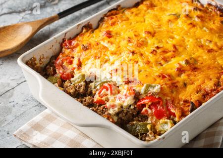 Casserole couches de bœuf haché, fromage, légumes frais et poivrons jalapeno cuits en gros plan sur le plat de cuisson sur la table. Horizontal Banque D'Images