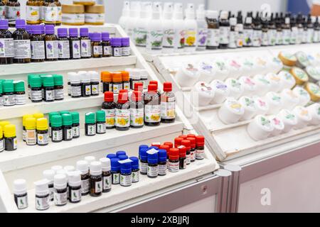 Osijek Croatie - 7 06 2024 : salon de la santé et de la beauté. présentoir blanc sur un marché, présentant une variété d'huiles essentielles dans de petites bouteilles en verre. Th Banque D'Images